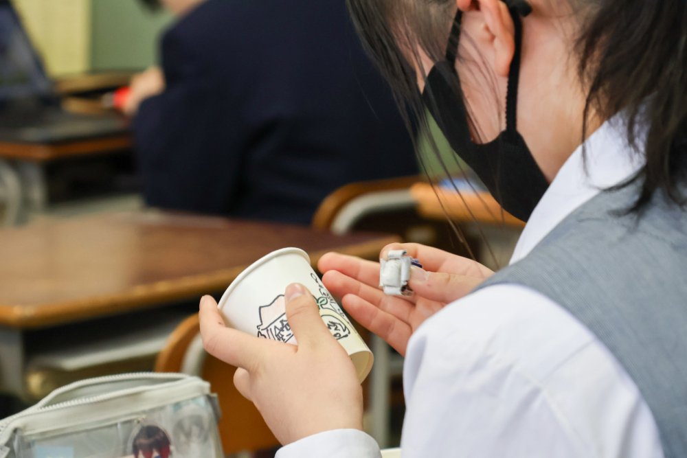 小学生へプレゼントする紙コップを作る生徒